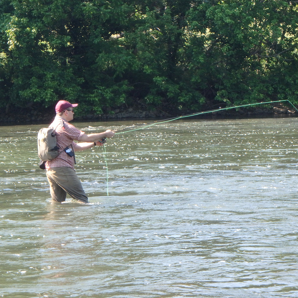 Half Day Fly Fishing Lessons - Showing an angler holding a fly rod standing in the Shenandoah River of Virginia learning to fly fish for smallmouth bass