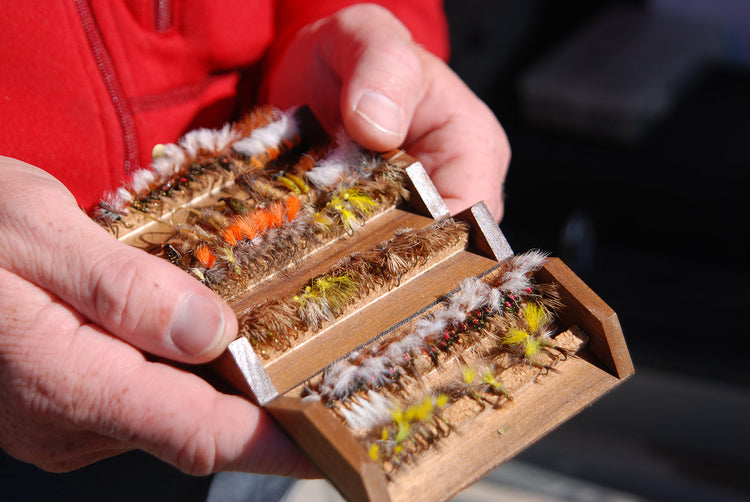 Virginia Fall Trout Fishing Essentials Shenandoah Valley showing an angler holding a fly box full of flies