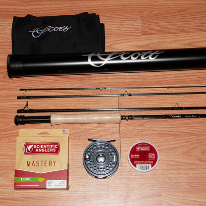 Scott Centric Fly Fishing rod, reel, and accessories on a wooden surface with Scott branding.